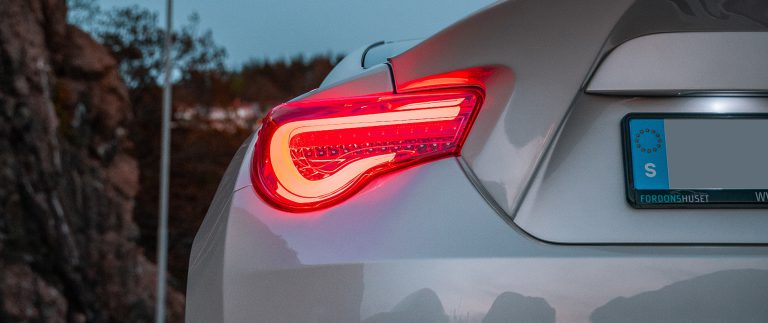 the tail light of a sports car in the dark